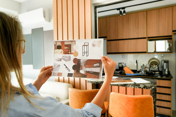 Over-the-shoulder view of a female architect reviewing a tailored home interior design plan in Dubai
